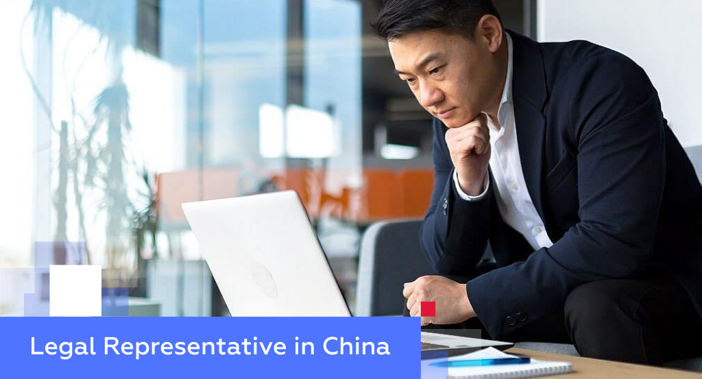 Asian executive reviewing documents on a laptop in a modern office — illustrating the legal representative role in China