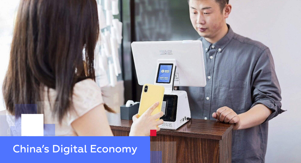 Customer using a smartphone for QR-code mobile payment at a Chinese counter — illustrating China’s digital economy