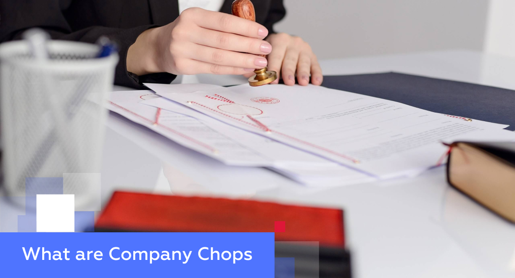 Hands pressing a red Chinese company chop seal onto a signed contract — illustrating what company chops are and how they authenticate documents in China